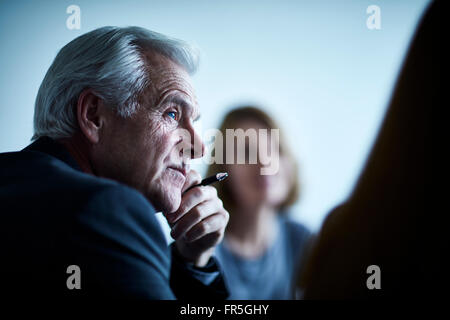 Attento businessman senior di ascolto in riunione Foto Stock
