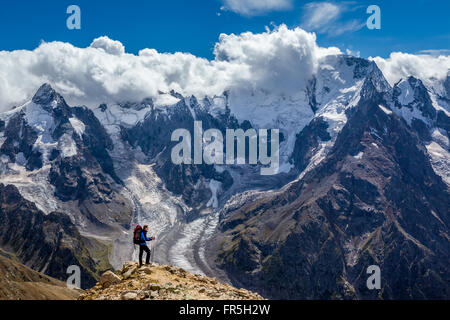 Escursionista con zaino in piedi sulla cima della montagna e godendo di scena Foto Stock