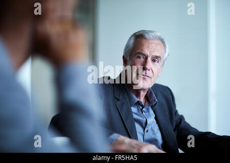 Attento businessman senior di ascolto in riunione Foto Stock