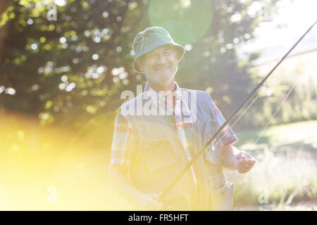 Ritratto sorridente uomo senior con canna da pesca Foto Stock