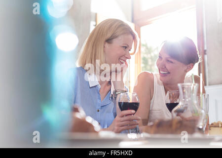 Donna sorridente bere il vino Foto Stock