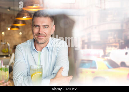 Ritratto fiducioso uomo a livello urbano cafe finestra Foto Stock