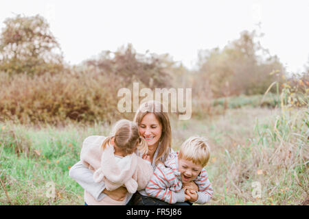 La madre e il bambino bambini abbracciando in autunno park Foto Stock