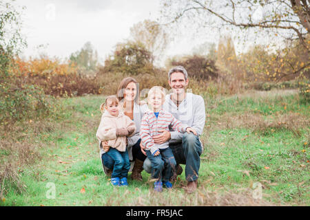 Ritratto di famiglia sorridente nel parco rurale Foto Stock