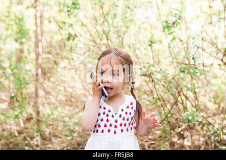 Il Toddler girl parlando al cellulare in posizione di parcheggio Foto Stock