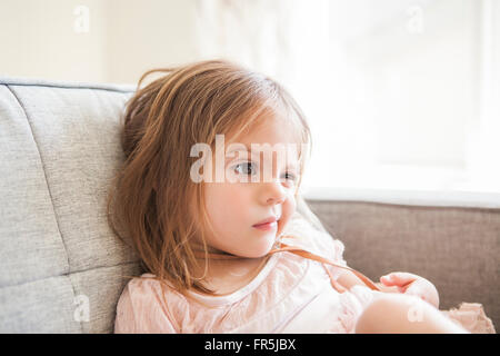 Il Toddler girl facendo una faccia sul divano Foto Stock