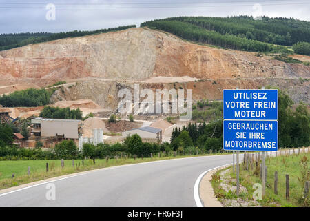 Segnale di avvertimento in corrispondenza di strada d'ingresso ad una cava aperta in montagna delle Ardenne belghe Foto Stock