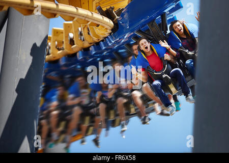 Giovane uomo urlando sul parco dei divertimenti di corsa Foto Stock