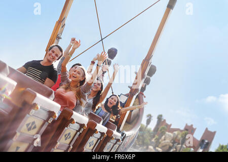 Gli amici a fare il tifo per il parco di divertimenti ride Foto Stock