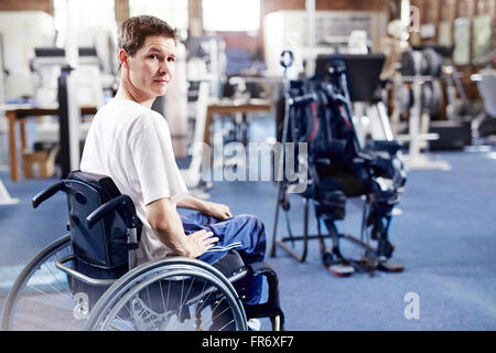 Uomo in sedia a rotelle in attesa per la terapia fisica Foto Stock