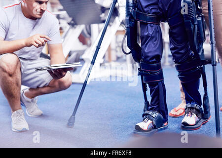 Fisioterapista guardare l uomo a piedi Foto Stock