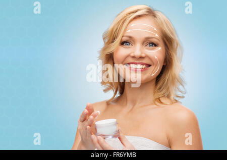 Donna felice con il vasetto di crema Foto Stock