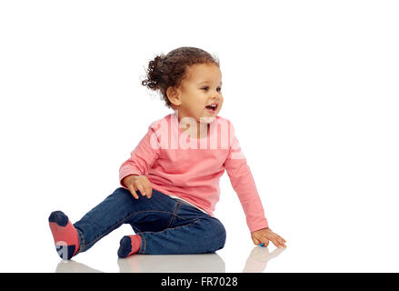 Sorridente bambina ragazza seduta sul pavimento Foto Stock