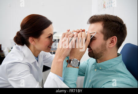 Ottico con pupilometer e paziente alla clinica oculistica Foto Stock