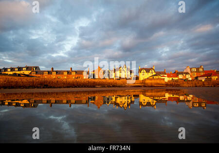 20/03/2016, il sole tramonta su una fila di case si riflette nell'acqua a Elie, una città costiera in East Neuk di Fife, Scozia. Foto Stock