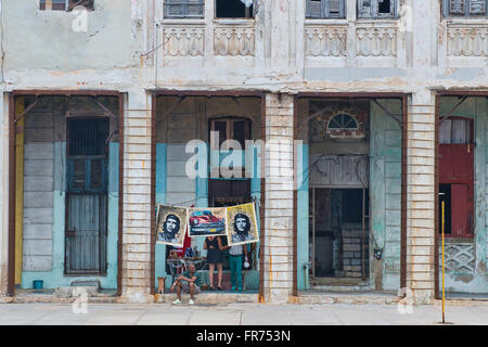 Poster di Che Guevara appendere in vendita tra le facciate decadenti di l'Avana del malecón. Foto Stock