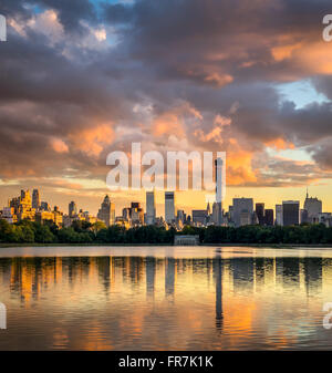 Fiery vista al tramonto di fronte al Central Park di Jacqueline Kennedy Onassis serbatoio verso il Midtown Manhattan skyline di New York City Foto Stock