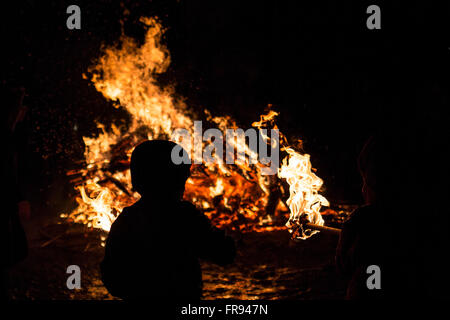 Un giovane bambino sta partecipando a un rito del fuoco durante una celebrazione di Sirni Zagovezni. Si ritiene che gli spiriti malvagi sono c Foto Stock