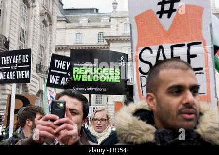 I dimostranti sono holding placards lettura: "i profughi Benvenuto " e " sono noi siamo loro' Foto Stock