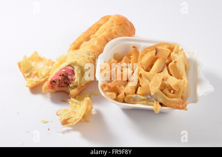 Il marcio vecchia potato chips e un rotolo di salsiccia con batteri e muffa che mostra su di esso. Foto Stock