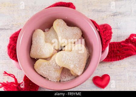 A forma di cuore biscotti in una ciotola rosa Foto Stock