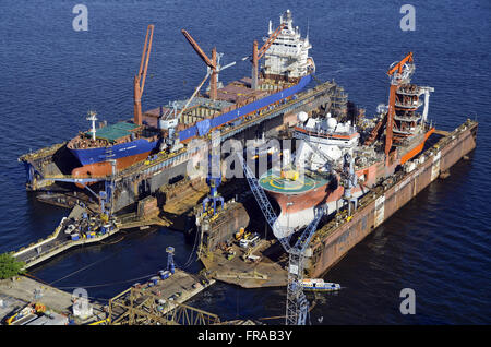 Vista aerea della nave mercantile e rimorchiatore agganciato per riparazioni in un cantiere navale - Baia Guanabara Foto Stock