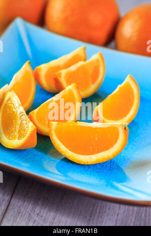 Freschi fette di arancia servito sulla piastra blu Foto Stock