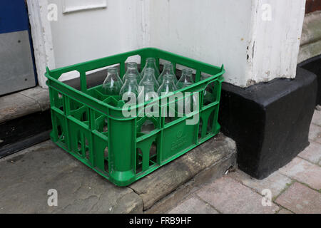 Svuotare bottiglie di latte raffigurato in un rack di verde su un passo in Winchester, Hampshire, Regno Unito. Foto Stock