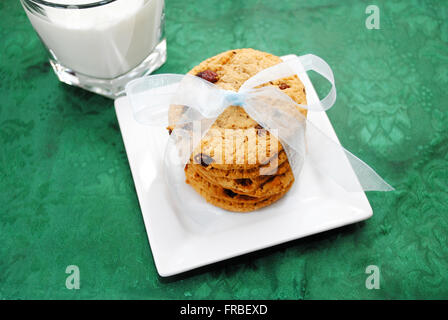 Gocce di cioccolato biscotti con un inchino e latte Foto Stock