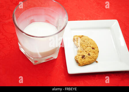 Mezza mangiata cookie con un quasi vuoto bicchiere di latte Foto Stock