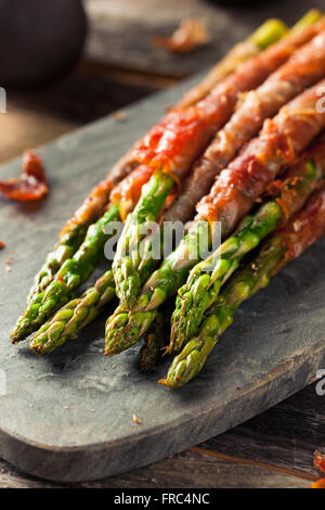 Il prosciutto casalingo avvolti gli asparagi con sale e pepe Foto Stock