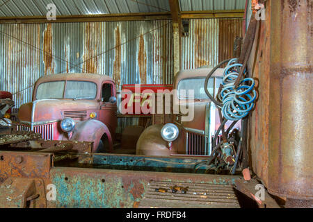 Arrugginimento antique pick-up e semi rimorchio cabina di autocarro in un capannone, Foto Stock