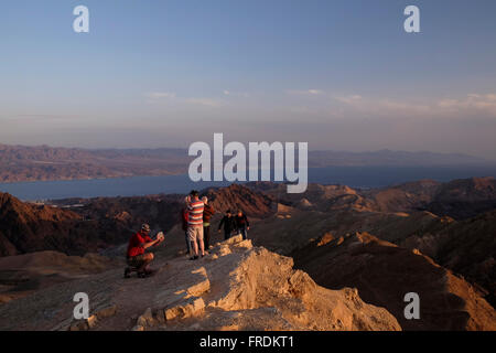 Gli escursionisti in corrispondenza di una piattaforma di osservazione in mount Yoash a Eilat montagne Riserva Naturale nel sud del deserto del Negev in Israele con la vista della punta settentrionale del Mar Rosso, ad est della penisola del Sinai e a ovest dell'Arabia Saudita sulla terraferma. Foto Stock