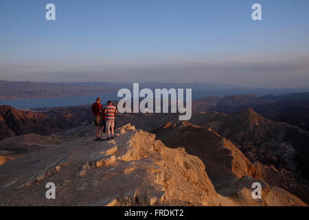 Gli escursionisti in corrispondenza di una piattaforma di osservazione in mount Yoash a Eilat montagne Riserva Naturale nel sud del deserto del Negev in Israele con la vista della punta settentrionale del Mar Rosso, ad est della penisola del Sinai e a ovest dell'Arabia Saudita sulla terraferma. Foto Stock