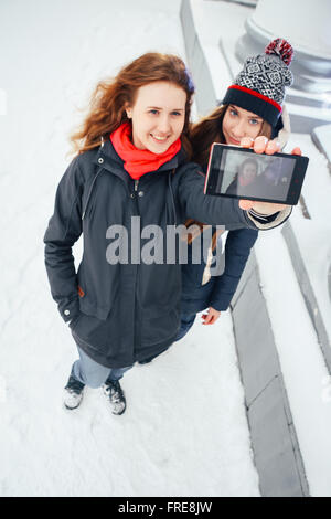 Due belle ragazze facendo selfie su sfondo bianco Foto Stock