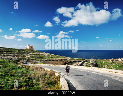 Pastore sulla strada vicino a Fort e costa mediterranea vista dell isola di Gozo a Malta Foto Stock