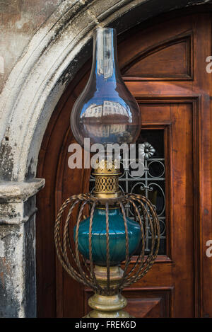 Vintage lampada di kerosene isolato. Vecchie porte austran sullo sfondo Foto Stock