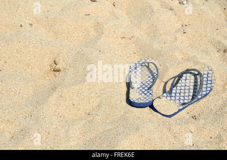 Blue flip flop sulla spiaggia di sabbia dorata Foto Stock