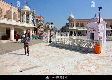 Scena di strada dove la vecchia città si incontra il nuovo sviluppo al di fuori del tempio d'oro di Amritsar Punjab, India del Nord. Foto Stock