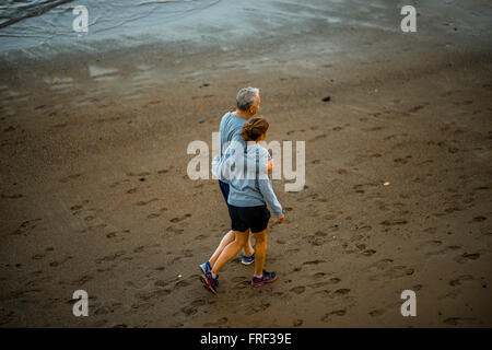 A Las Palmas di Gran Canaria Island, Spagna - 1 dicembre 2015: Elder giovane vestito simili in vestiti sport passeggiate sulla spiaggia di Foto Stock