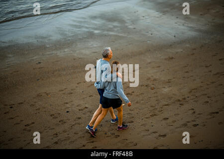 A Las Palmas di Gran Canaria Island, Spagna - 1 dicembre 2015: Elder giovane vestito simili in vestiti sport passeggiate sulla spiaggia di Foto Stock