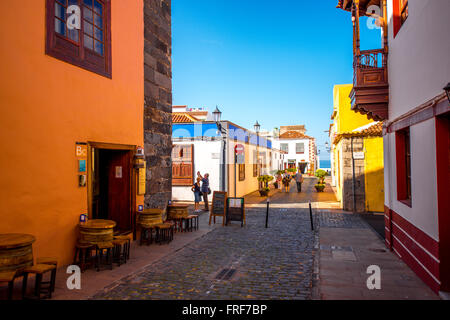 A Garachico, isola di Tenerife, Spagna - 16 dicembre 2015: vista sulla strada con i suoi edifici colorati e turisti a piedi in Garachico cit Foto Stock
