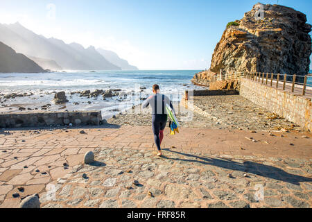 BENIJO, isola di Tenerife, Spagna - 23 dicembre 2015: Surfer acceso all'oceano per fare surf sulla spiaggia Benijo sulla parte settentrionale Foto Stock