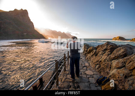 BENIJO, isola di Tenerife, Spagna - 23 dicembre 2015: uomo fotografare la costa rocciosa in Benijo villaggio sulla parte settentrionale di Tene Foto Stock