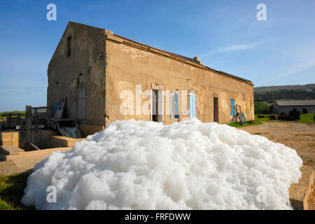 Pag, Croazia - vecchio lavoro di sale, sale-acqua di schiuma nel processo di realizzazione di sale Foto Stock