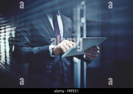 Close-up di imprenditore con touchpad networking nel corridoio di edificio per uffici Foto Stock