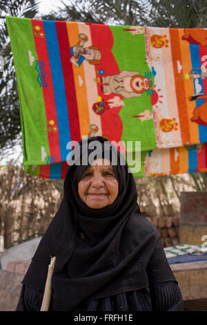 Ritratto di un 88-anno vecchio donna locale con un background di asciugare gli asciugamani in Bairat, un villaggio sulla riva occidentale di Luxor, la Valle del Nilo in Egitto. Foto Stock