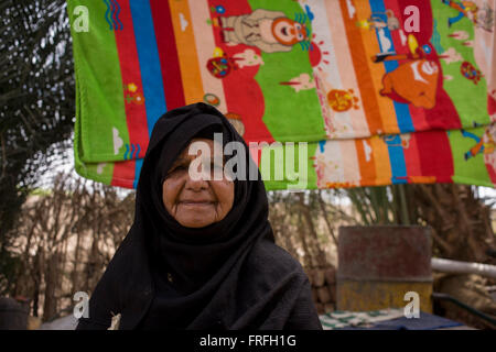 Ritratto di un 88-anno vecchio donna locale con un background di asciugare gli asciugamani in Bairat, un villaggio sulla riva occidentale di Luxor, la Valle del Nilo in Egitto. Foto Stock
