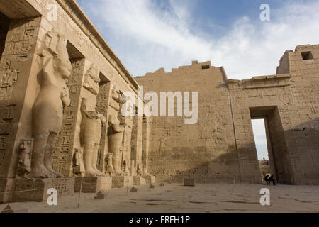 Meno turisti, alte colonne Ramessid nel peristilio corte presso gli antichi egiziani sito di Medinet Habu (1194-1163BC), il tempio mortuario di Ramesse III a Luxor, la Valle del Nilo in Egitto. Medinet Habu è un nuovo importante periodo del regno di struttura nella West Bank di Luxor in Egitto. A parte la sua dimensione e la sua importanza architettonica ed artistica, il tempio è probabilmente meglio conosciuto come sorgente di inscritto rilievi raffiguranti l'avvento e la sconfitta dei popoli del mare durante il regno di Ramesse III Foto Stock