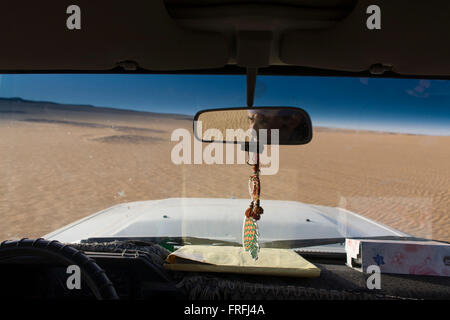 Un beduino aziona il suo veicolo 4x4 attraverso dune di sabbia del deserto di al-Galamun, vicino Dahkla oasi, Western Desert, Egitto. Gli ultimi decenni sono stati difficili per la tradizionale cultura beduina dovute al cambiamento delle frazioni e la creazione di nuove città di villeggiatura sulla costa del Mar Rosso come Sharm el-Sheikh. I beduini in Egitto si trovano di fronte a un certo numero di sfide: erosione dei valori tradizionali e la disoccupazione e a varie questioni del territorio. Il Deserto Occidentale copre un area di 700.000 km2, contribuendo così per circa i due terzi dell'Egitto la superficie totale .. (Continua nella descrizione). Foto Stock